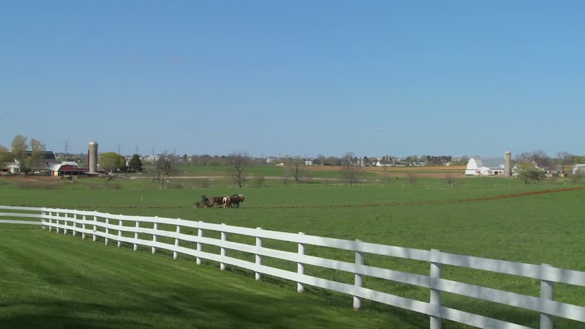 Amish country with farmer farming the land.