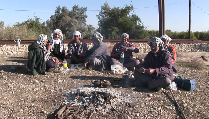 IRAN - CIRCA 2010: Men wearing the traditional muslim headdress, or keffiyeh, sit by a fire outside circa 2010 in Iran. 