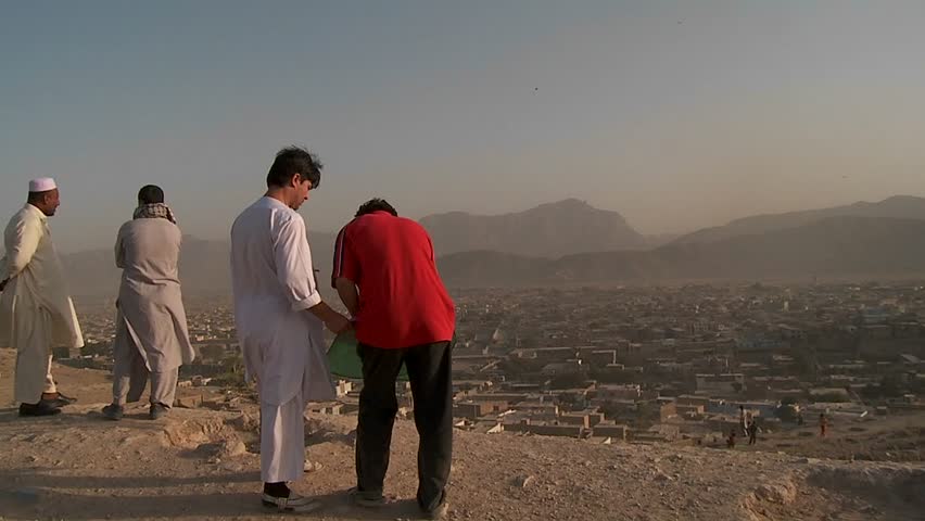 KABUL, AFGHANISTAN - CIRCA 2009: Men fly kites on a hill overlooking circa 2009 in Kabul, Afghanistan. Afghanistan is an impoverished and least developed country, one of the world's poorest. 