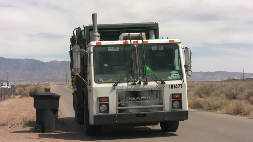 Trash truck picking up a trash can and dumping it. Editorial use only due to visible logos.