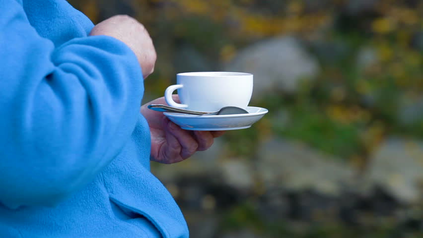 senior woman hands holding white coffee cup outdoors Differential Focus, Unrecognizable Person,  Side View