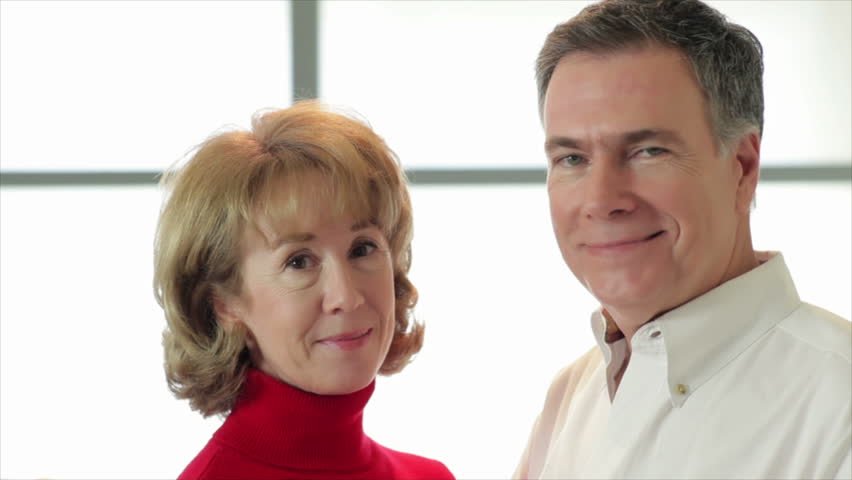 A happy mature heterosexual couple smile for the camera.
