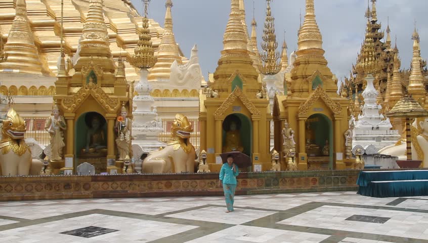 YANGON, MYANMAR - AUGUST 18: Women walking near basement of Shwe Dagon Pagona, August 18, 2011, Yangon, Myanmar. Buddhism in Burma (aka Myanmar) is predominantly of the Theravada tradition, practiced by 89% of the country's population.