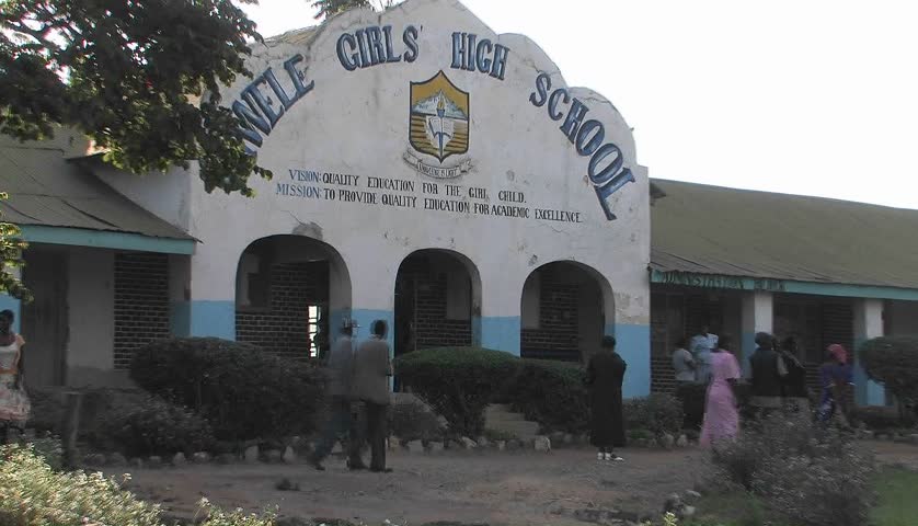 KENYA, AFRICA - CIRCA 2009: People walk past a high school in Africa circa 2009 in Kenya.