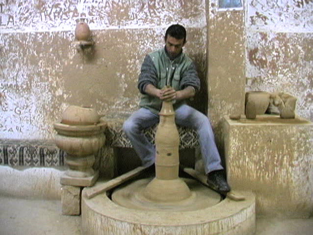 Using the old fashtion way to make ceramic pottery.  Worker uses his leg to turn the wheel to make the sugar bowl