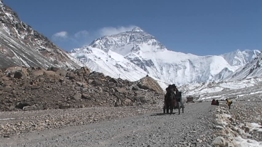 MOUNT EVEREST, NEPAL - CIRCA 2005: Tibetan men and climber ride in a carriage pulled by a horse near base camp circa 2005 on Mount Everest.