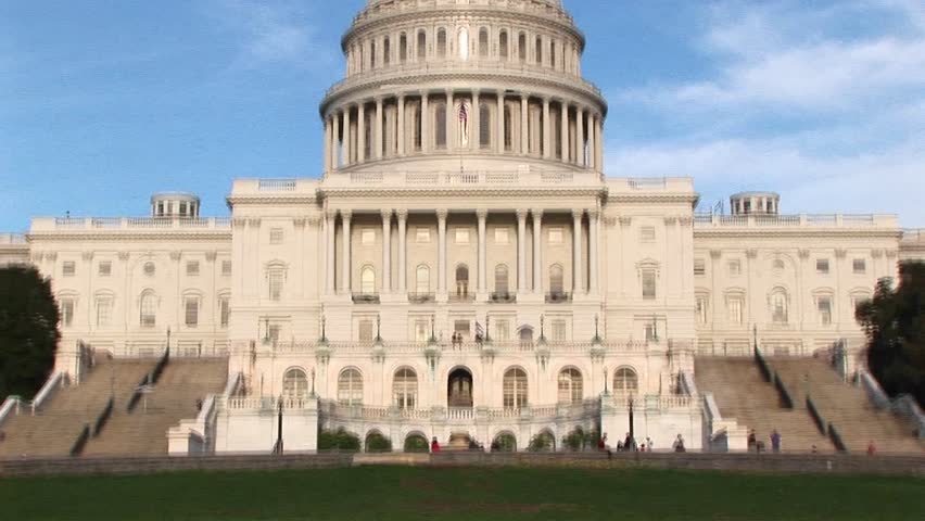 Panning up on the U.S. Capitol building in Washington, DC from ground level to its landmark rotunda, dome and the Freedom statue on top.