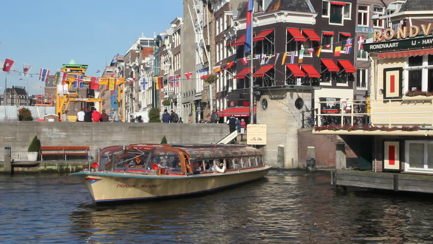 AMSTERDAM, HOLLAND - AUGUST 1: Tour boat sails in Amsterdam canal on August 1, 2011 in Amsterdam, Holland. The canal ring area is on the UNESCO World Heritage List.