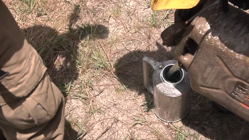 MS - Filling drip torches with fuel to conduct a prescribed fire in the Florida Everglades
