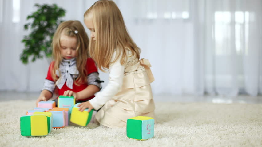 Children play with blocks of tissue. They learn the alphabet sitting on the carpet. DOLLY HD 
