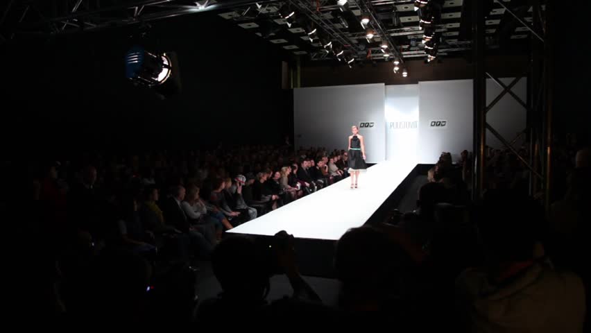 MOSCOW - NOVEMBER 19: Model in black dress and turquoise belt from Liliya Pustovit collection, walk on podium at Russian Fashion Week, on November 25, 2010 in Moscow, Russia.