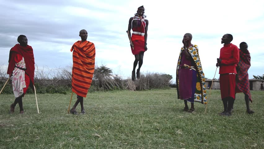 MASAI MARA, KENYA - OCTOBER 17: A young Masaai welcomes tourists with the traditional jumping ceremony on October 17, 2011 in Masai Mara, Kenya. The Maasai are a Nilotic ethnic group of semi-nomadic people located in Kenya and northern Tanzania. 