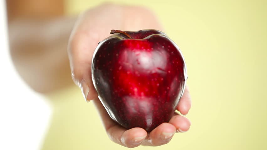 Apple. Woman showing holding red apple in closeup.