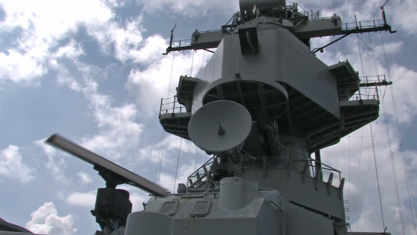 Battleship USS Missouri docked at Ford Island in Pearl Harbor, Honolulu, Oahu, Hawaii. Big deck guns aiming over the USS Arizona memorial in a protective stance. Superstructure and radar.