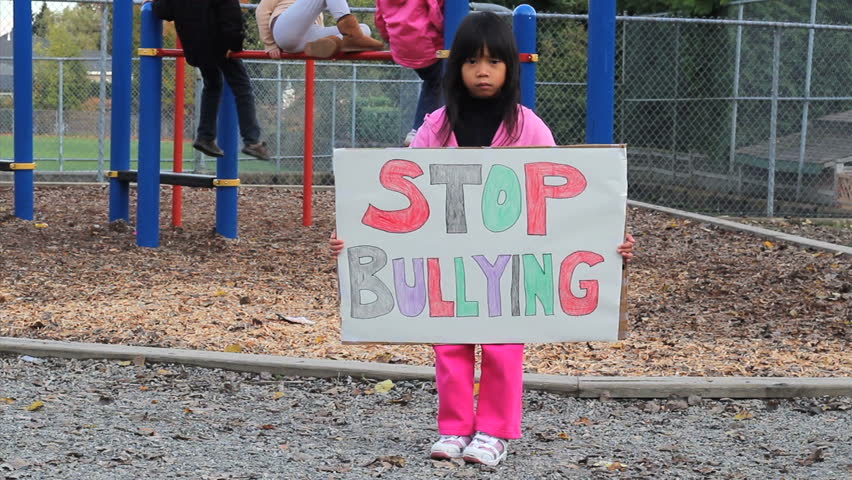 A little Asian girl carries a home made sign that she made to try to stop bullying at her local school.