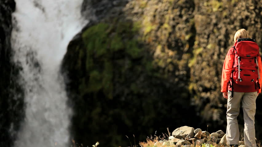 Female Hiker in front of glacial waterfall outdoor