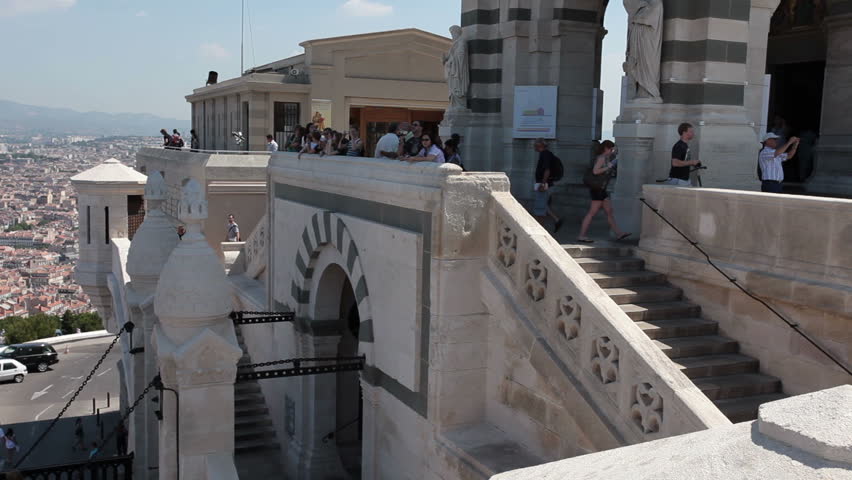 Tourists at Notre Dame de la Garde Cathedral pan across city and Mediterranean Sea. Marseille France May 23 2011.