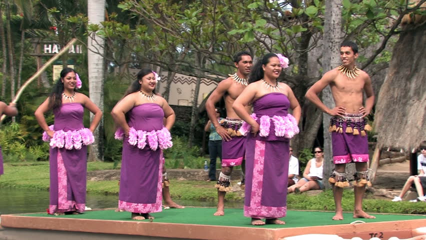 Polynesian Cultural Center in Laie Oahu Hawaii. Canoe show with dancers from Samoa. Demonstration for tourists in the main lagoon. Purple skirts on beautiful dancers. Water, lagoon and palm trees.