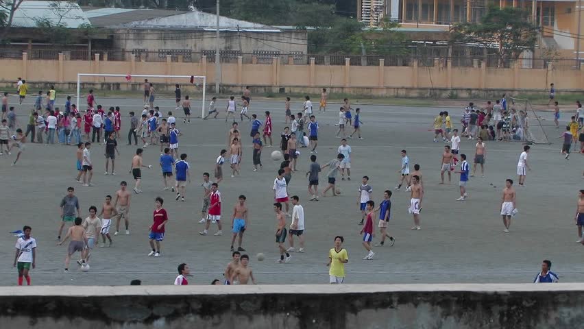 Boys in a school yard playing soccer.