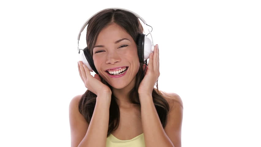 woman listening to music on headphones dancing isolated on white background. Beautiful happy smiling multiethnic Asian Caucasian female model.