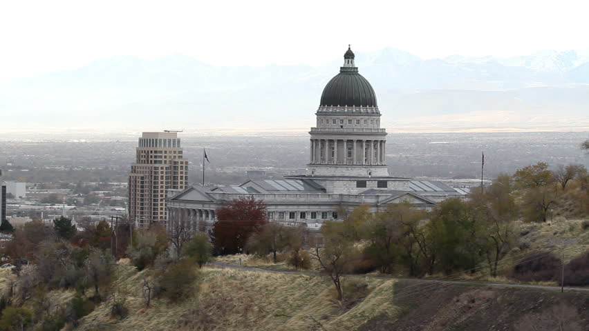 Utah State Capital from mountain looking through dome into valley and Salt Lake City. Normal haze from city. Traffic on mountain road leading to building