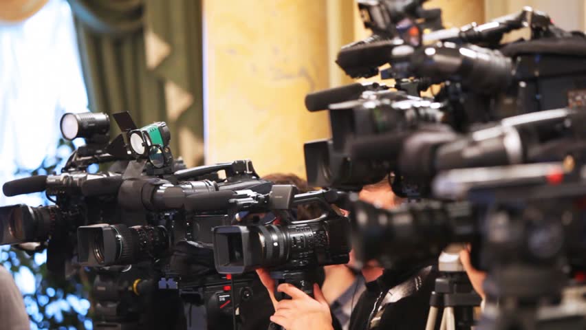 Some videocameras with operators close up recording presentation