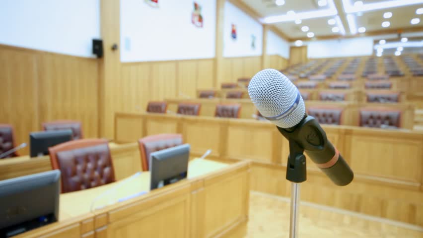 Microphone in empty big hall and hand which holds its close up