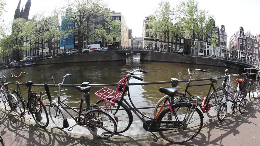 AMSTERDAM - CIRCA APR 2011: Bicycles line the railings in front of the canal circa April 2011 in Amsterdam.