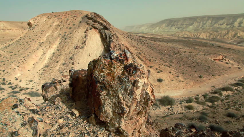 Slider dolly move left to right taken from a small rocky hill in the desert of the Mitzpe Ramon Crater in Israel.  