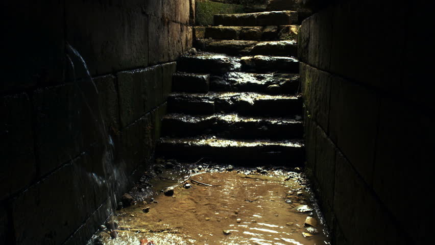 rain water pouring in from a crack in the rock walls and water flowing down the steps at the Palace of Agrippa in Banias, Golan Heights, Israel.  