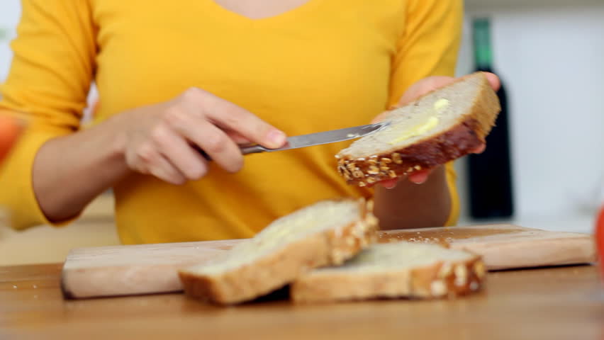 Young woman eating loaf of bread with butter, camera stabilizer shot