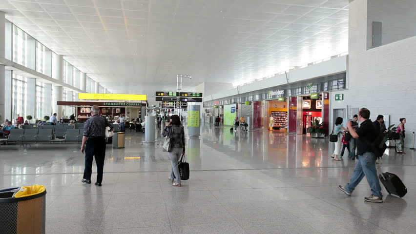 MALAGA, SPAIN MAY 2011: Passengers and airport employees walking through terminal and concourse at Malaga International Airport in Malaga, Spain. Business and vacation travel.