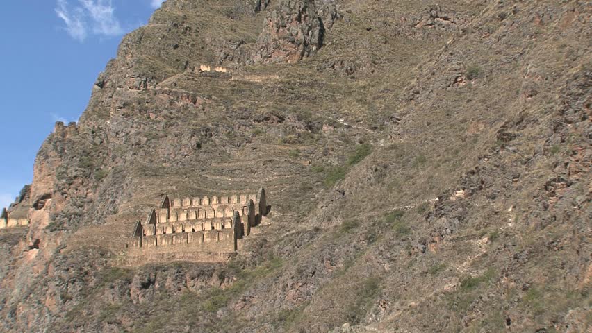 Tilt-up from Ollantaytambo storehouses to Peruvian flag