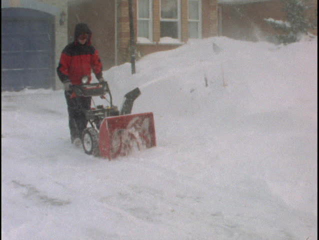 Man snowblowing driveway