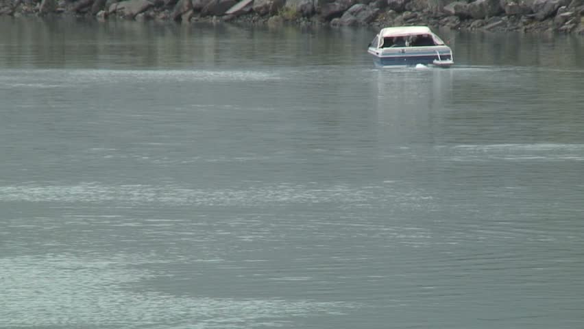 AK, PORTAGE, UNITED STATES OF AMERICA - 8/10/2007 Fish Jump Out Of Water Behind Motorboat