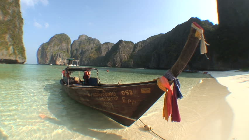 KO PHI PHI, THAILAND - CIRCA 2011: Along boat drifts back and forth in an exotic cove
