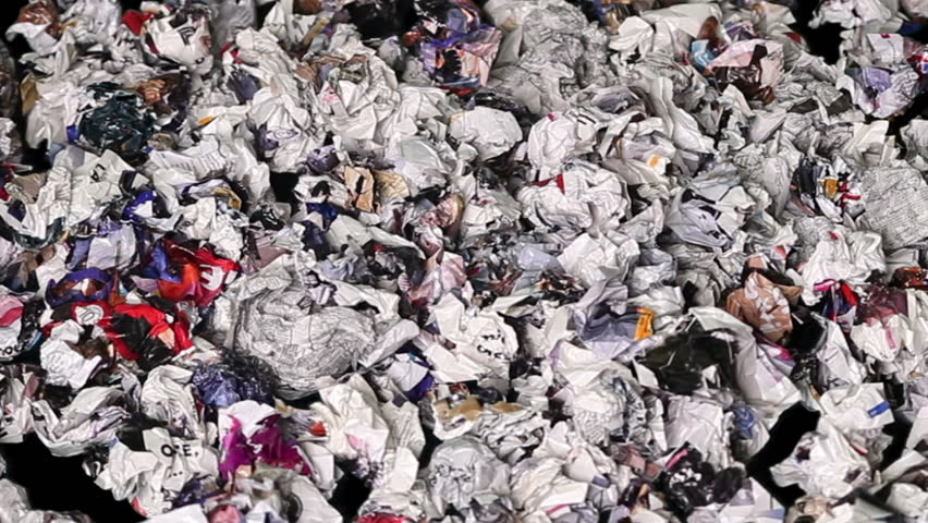 Paper rubbish and garbage cast against black background. Time lapse. 