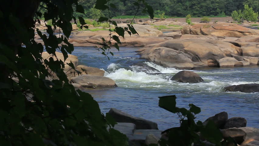 Beautiful rocky river vista through trees from river bank - HD dslr
