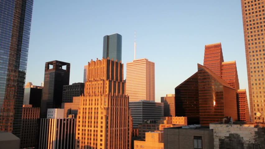 Golden early morning light bathes and reflects off the variety of architectural designs that make up metropolitan downtown Houston Texas.