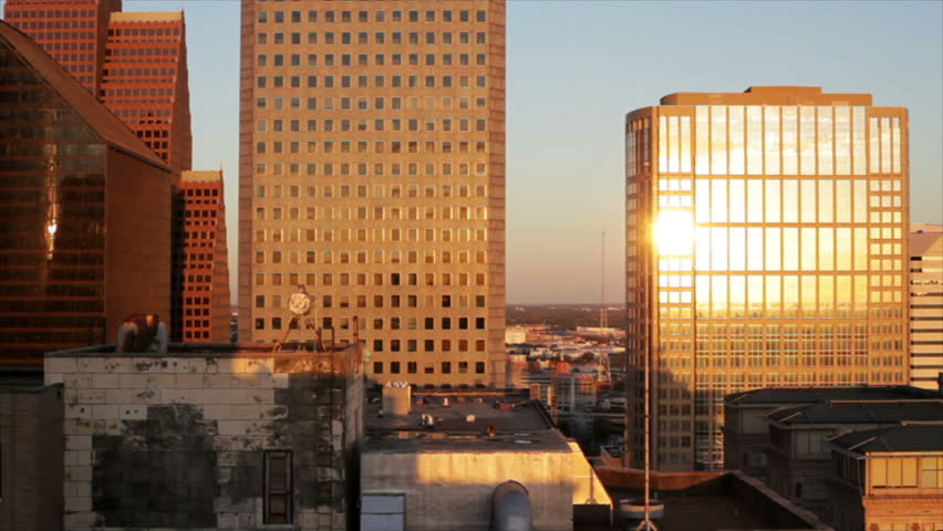Golden early morning light bathes and reflects off the variety of architectural designs that make up metropolitan downtown Houston Texas.