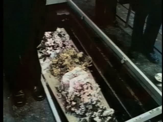Medium shot of coffin lowered into grave