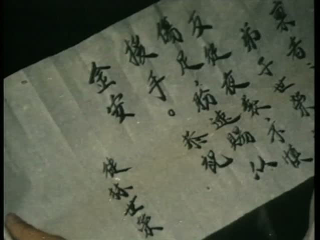 Close-up hands crumpling note written in Chinese
