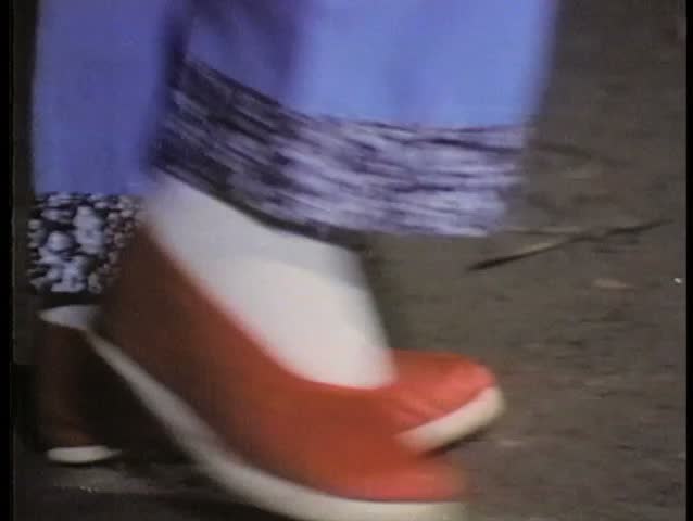 Close-up feet in red Chinese slippers walking across floor