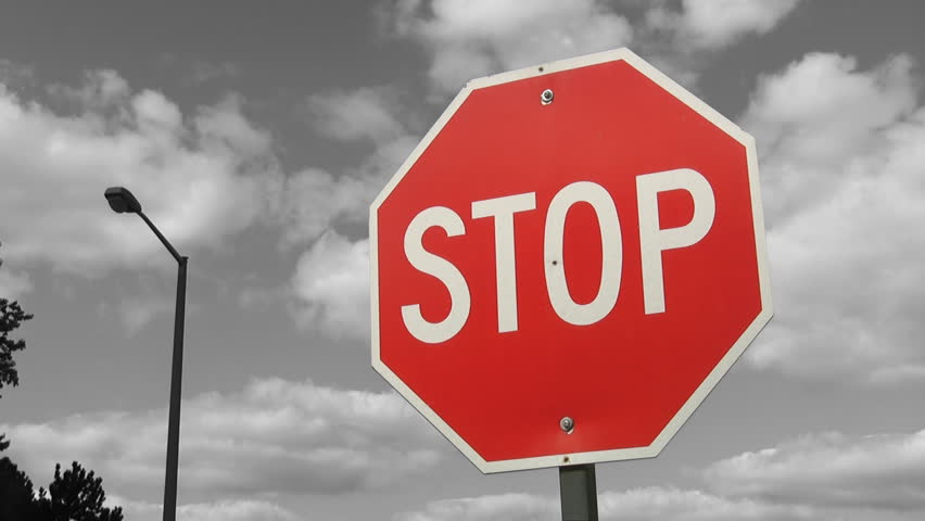 Stop sign with grey timelapse clouds. 