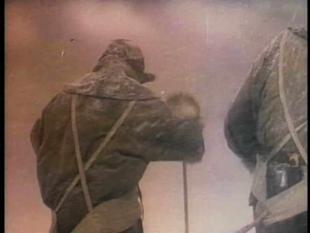 Men on expedition trudging through snow storm in Antarctica
