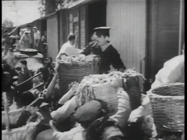 Peasants filling up baskets with food and loading on train