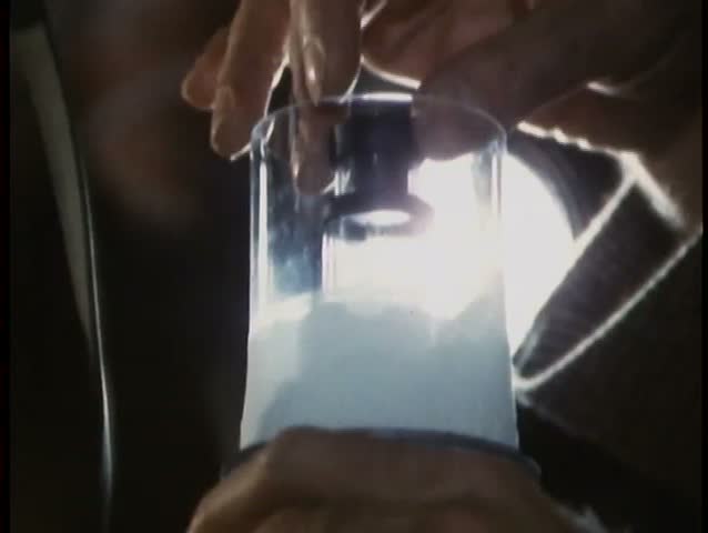 Close-up of hand picking up test tube