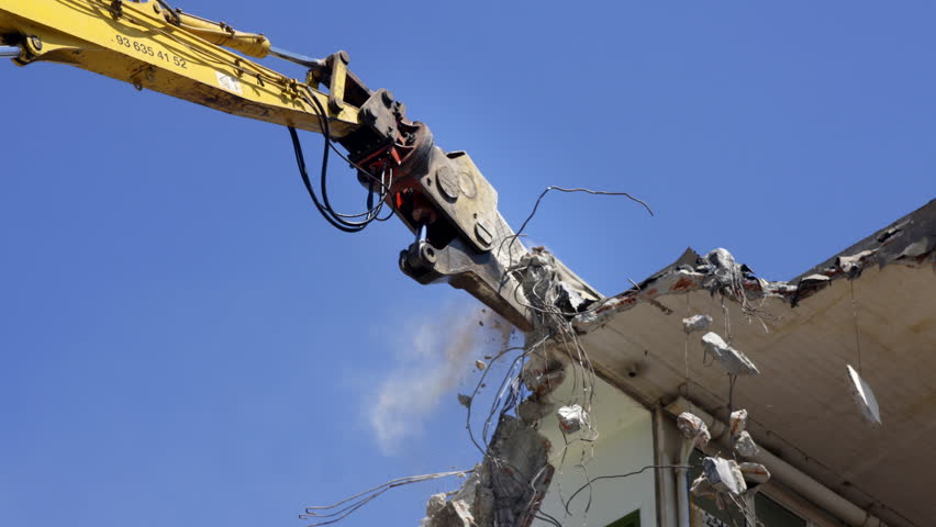a crane breaking down a building, looking a bit like like a dinosaur eating!