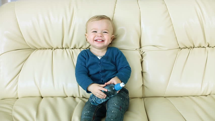 Laughing baby boy a bottle of water