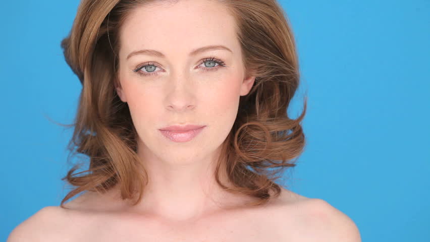 Beautiful woman using a cotton pad to cleanse her face in a skincare and personal hygiene concept